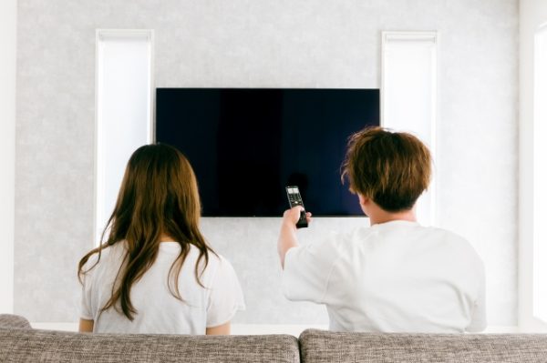 テレビを見ているカップル